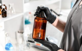 Una persona manipula una botella con un producto químico en su interior.